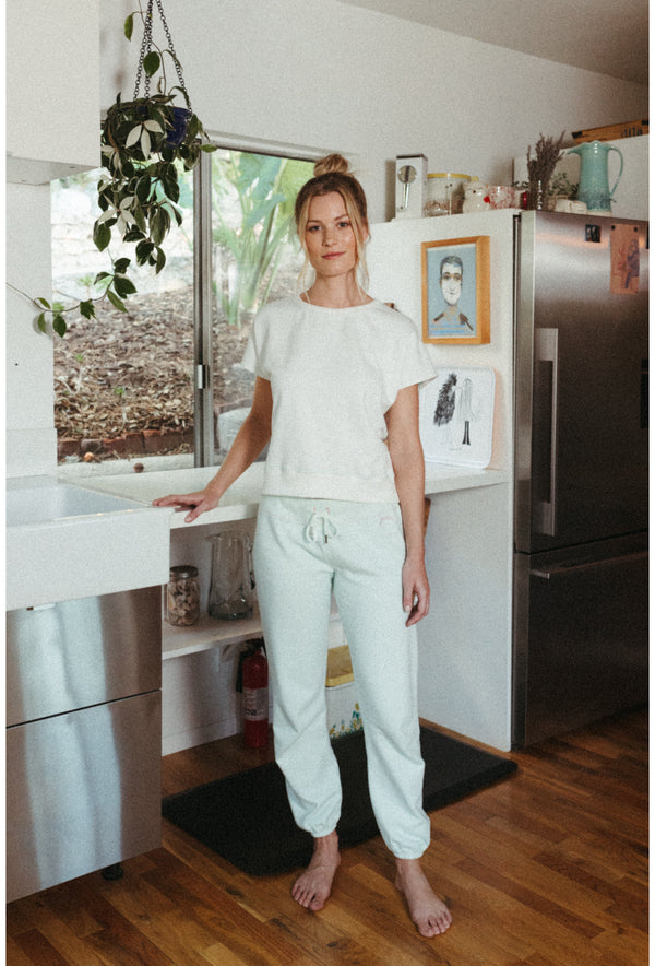 Women's organic cotton terry sweatpants with vintage pink contrast stitching, cropped 70s-inspired fit.